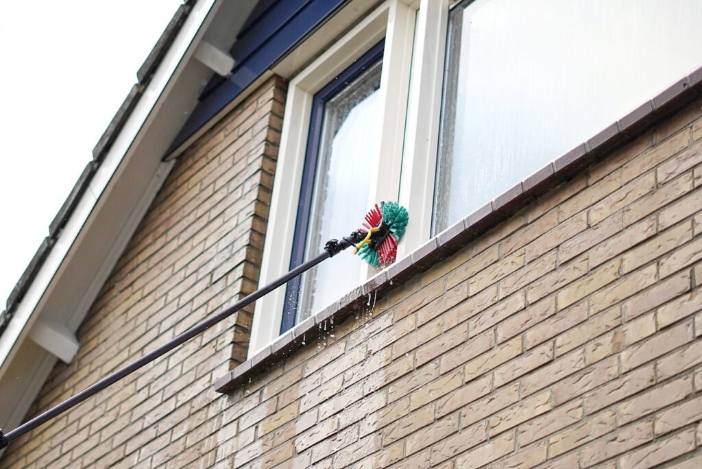 Kunststof kozijnen en gevels schoonmaken met een telescoopborstel in Friesland. Voorjaarschoonmaak.